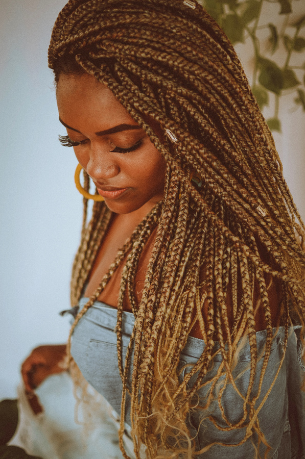 Afro woman with braids looking down